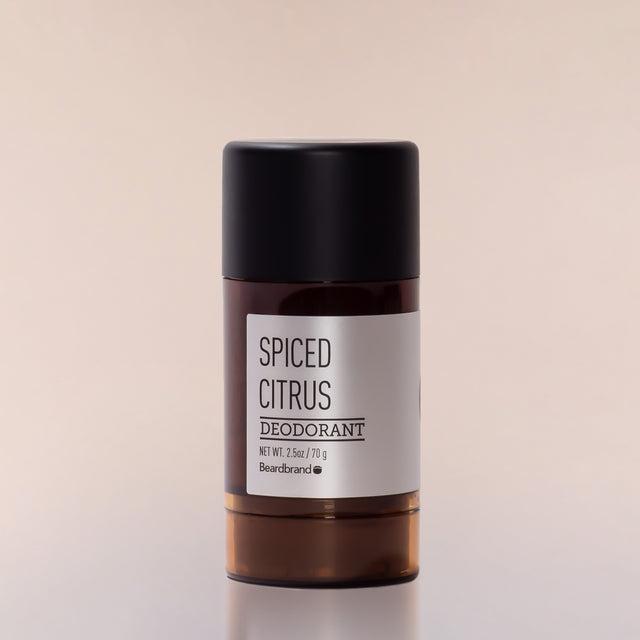 A round tube of Beardbrand Spiced Citrus Deodorant against a neutral background.