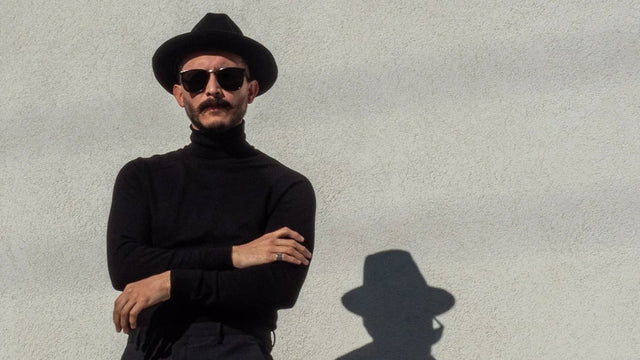 Stylish man with a goatee wearing a black fedora and turtleneck 